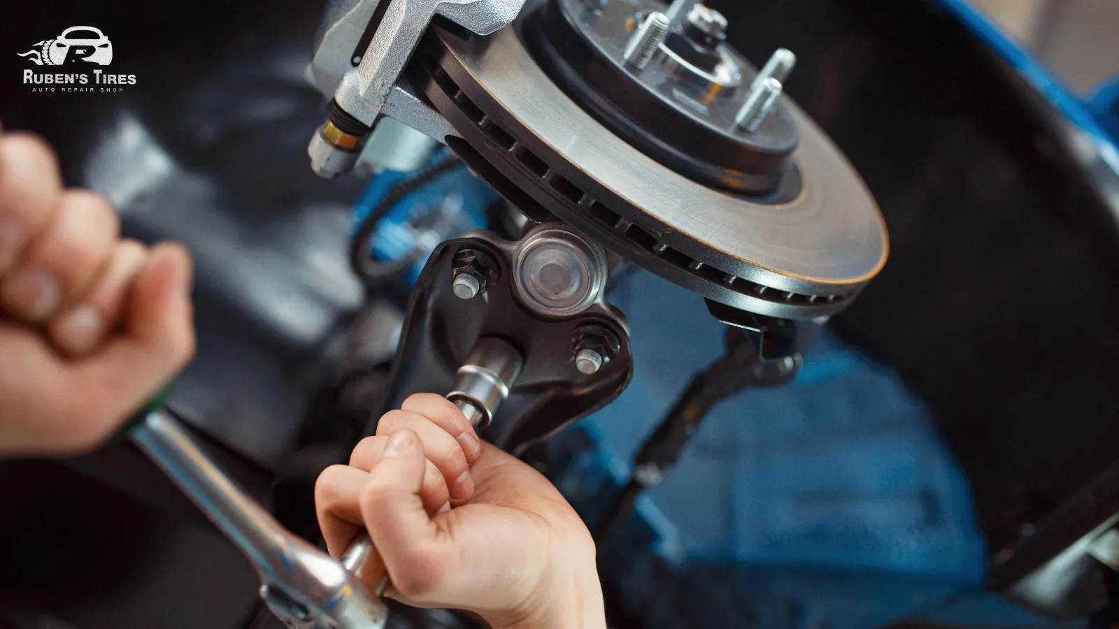 Mechanic inspecting brake components for effective car maintenance at Ruben's Tires.