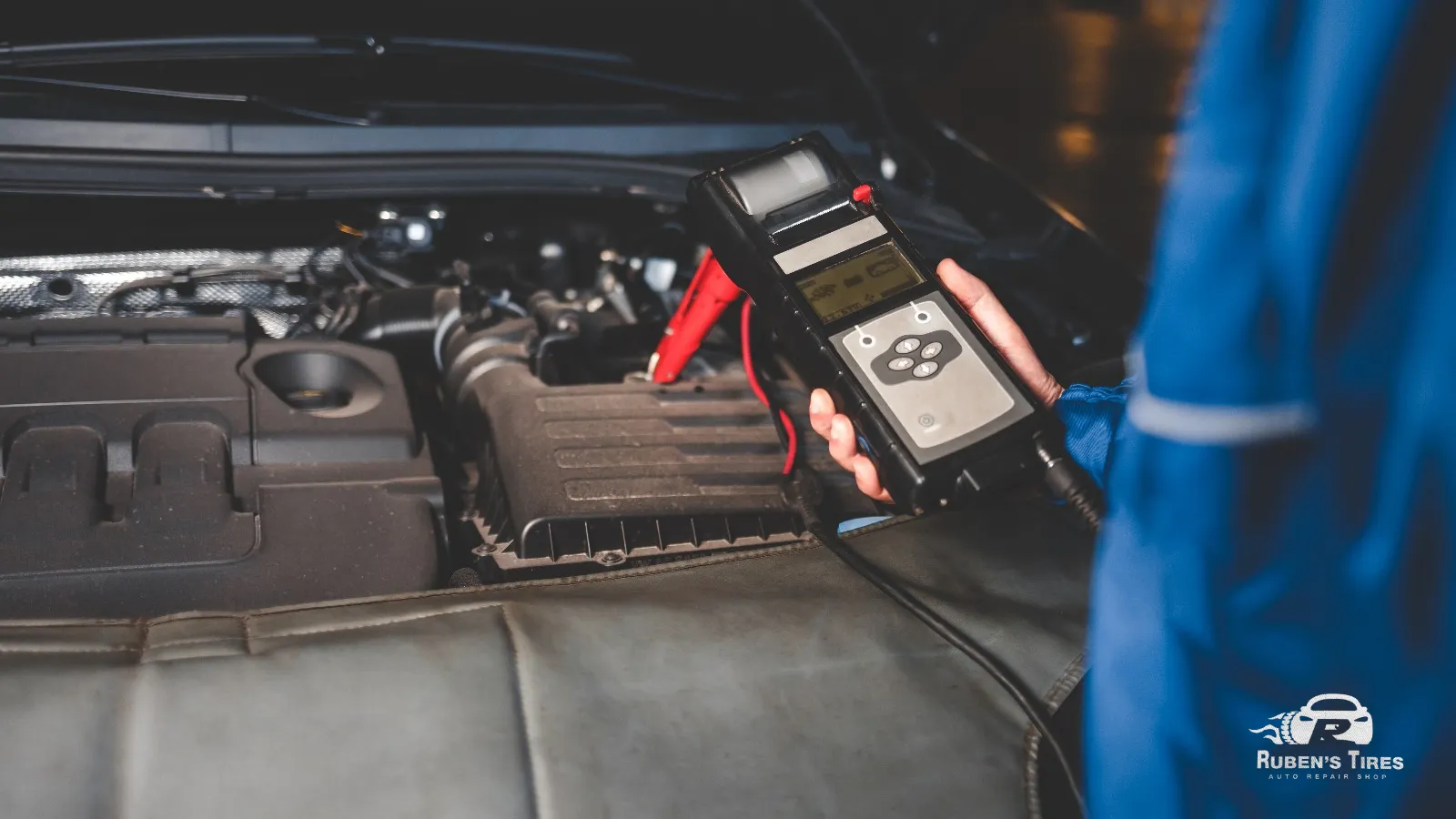 Mechanic testing car battery voltage as part of routine car maintenance at Ruben's Tires.