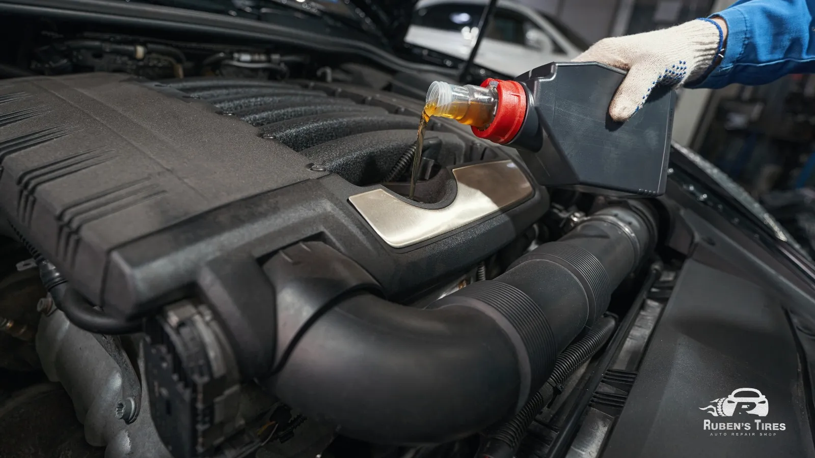 Mechanic pouring fresh engine oil during routine car maintenance at Ruben's Tires.