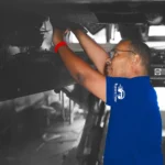 Technician performing suspension and steering inspection and repair on a vehicle at Ruben's Auto Body Shop Central Florida, ensuring safety and precision.