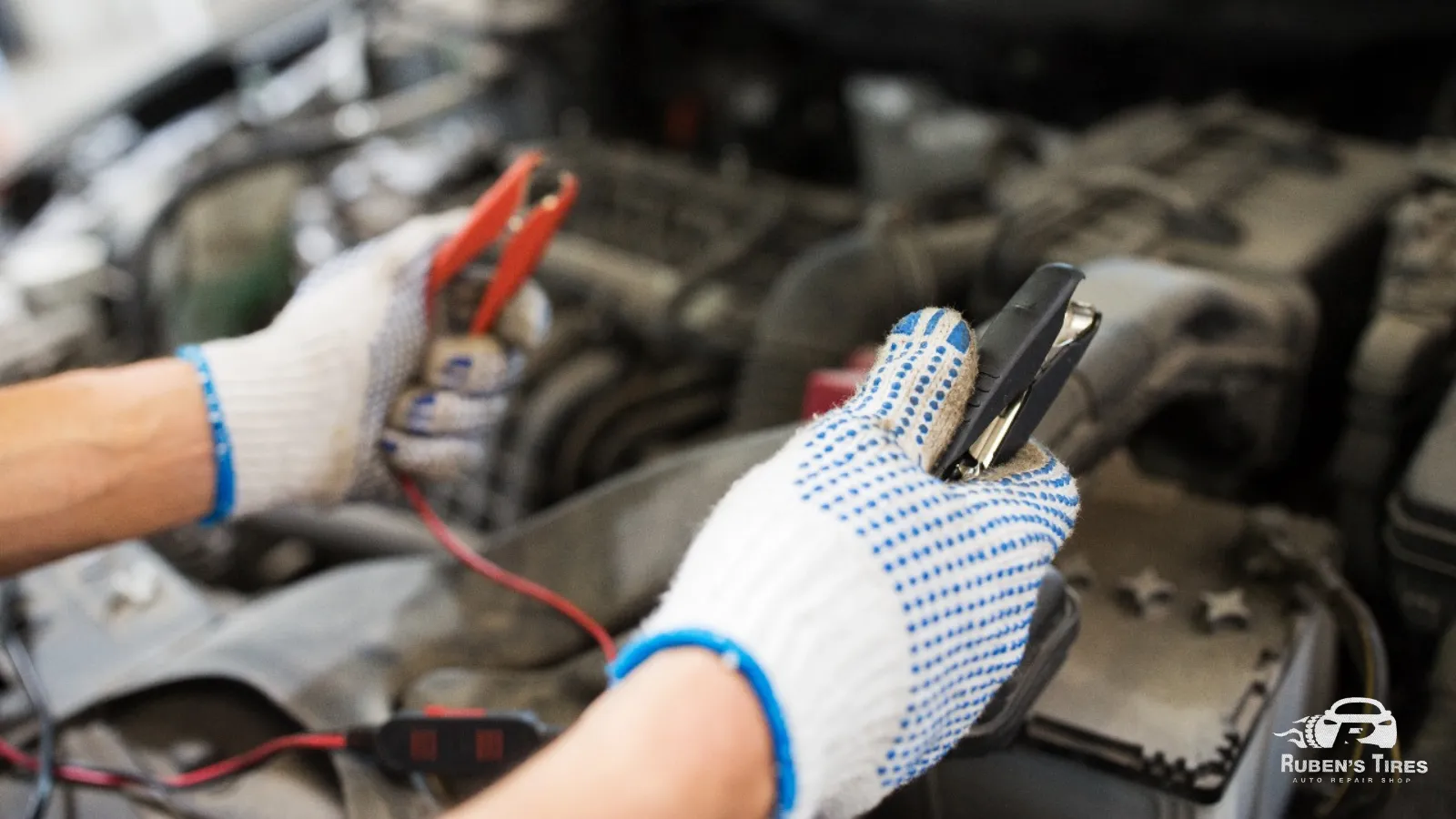 Mechanic performing a battery jump-start with professional tools at Ruben’s Auto Repair.