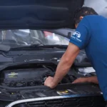 Experienced technician inspecting engine components under the hood, providing professional Brake Repair Central Florida services in a modern auto shop.