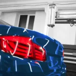 Close-up of a sleek blue car's rear with illuminated taillights in a professional garage, highlighting expert Auto Repair Tips Central Florida for vehicle maintenance and care.