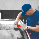 Technician applying tint film to a car window with precision, showcasing expert Car Window Tinting Central Florida services for enhanced style and UV protection.